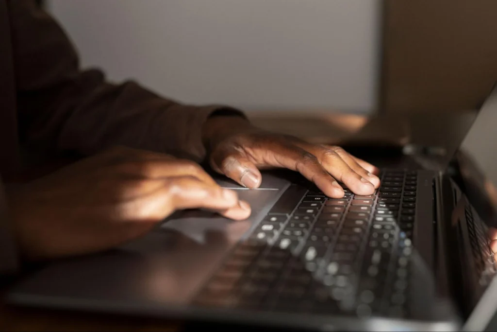 Hands typing on laptop